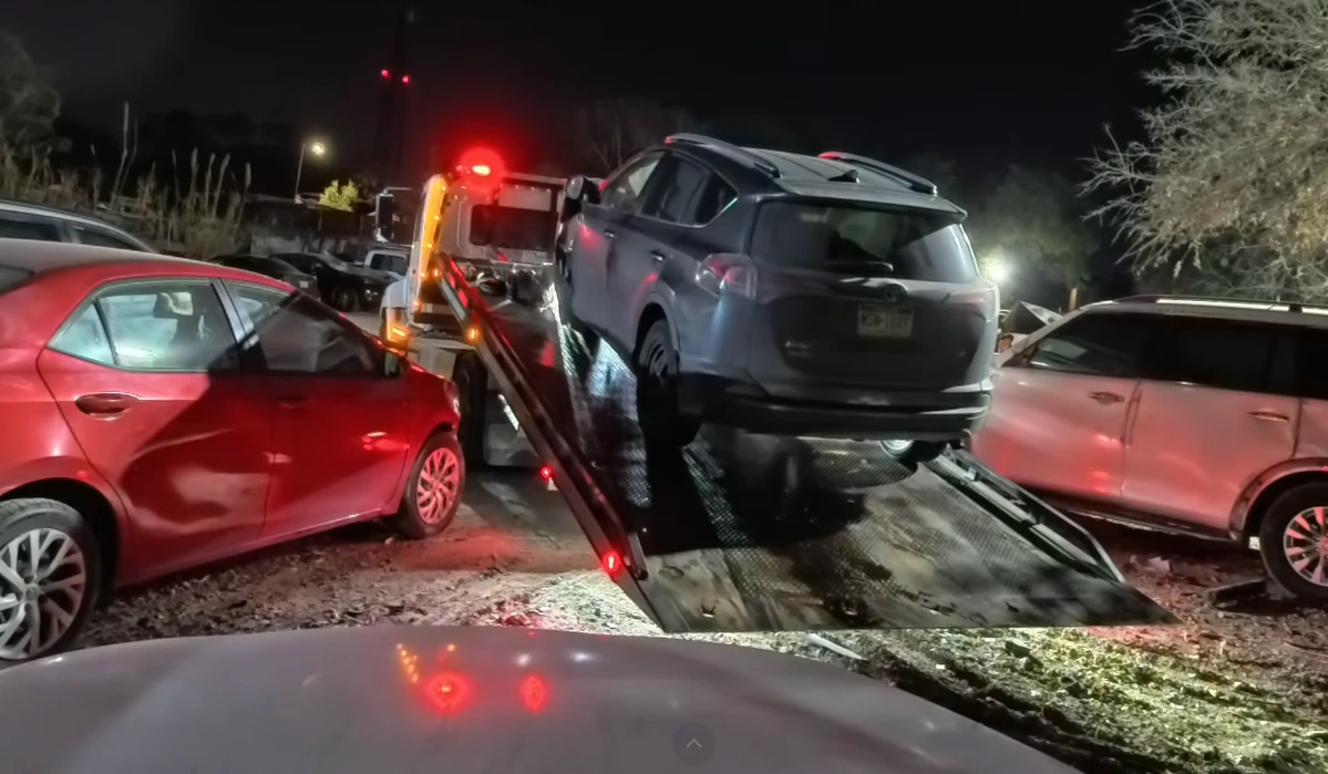 Tow truck dispatched overnight in Asheville NC with headlights on a dark mountain road