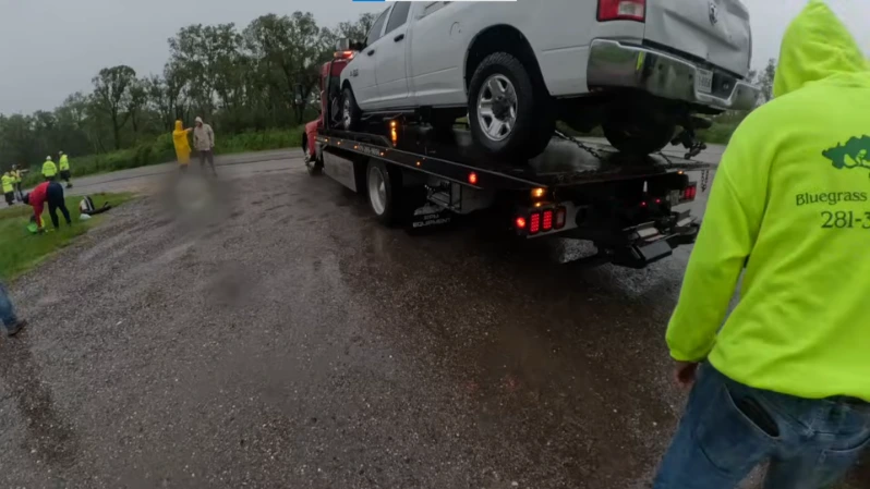 Flatbed tow truck loaded with a sedan departing Asheville NC for long distance transport