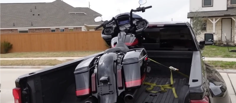 Custom lowered motorcycle being carefully loaded onto a flatbed for towing in Asheville NC