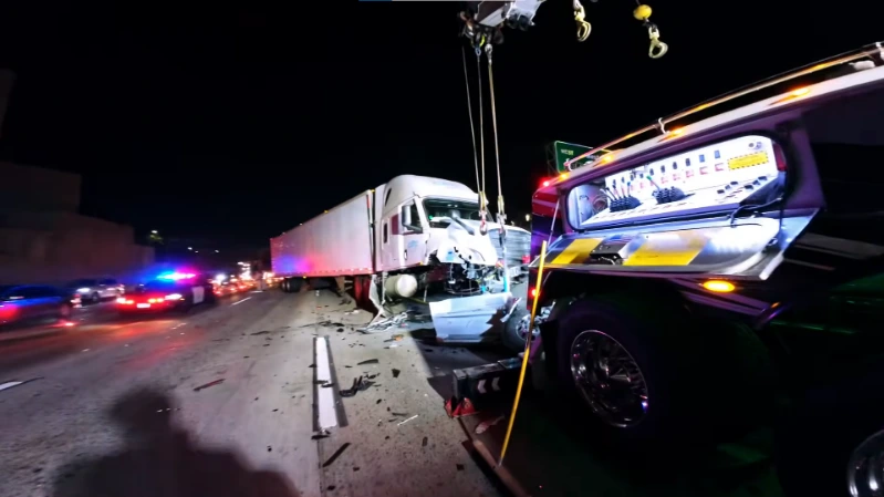 Tow truck recovering a vehicle after a black ice slide-off at night near the French Broad.